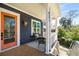 Inviting front porch with a bright orange door, wicker seating, and an exterior vintage-style copper lantern at 431 Clifton Ne Rd, Atlanta, GA 30307