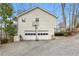 Detached garage with a basketball hoop and long driveway in a wooded setting at 8498 Colony Club Dr, Alpharetta, GA 30022