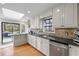 Well-lit kitchen boasting white cabinets, granite countertops, and hardwood floors at 8498 Colony Club Dr, Alpharetta, GA 30022