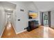 Open-concept living room with hardwood floors, neutral walls, and access to hallway and bathroom at 8498 Colony Club Dr, Alpharetta, GA 30022