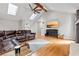 Bright living room with hardwood floors, a fireplace, a skylight, and a TV at 8498 Colony Club Dr, Alpharetta, GA 30022