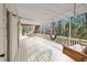 Relaxing covered back porch with a hanging swing and comfortable day bed for serene relaxation at 8498 Colony Club Dr, Alpharetta, GA 30022