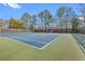 Enjoy a game of tennis on the well-maintained community court with green and blue surface and mature trees around the perimeter at 8498 Colony Club Dr, Alpharetta, GA 30022