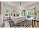 Bright bedroom features a ceiling fan, hardwood floors, a black and white rug, and doors to a balcony at 2175 James Aly, Atlanta, GA 30345