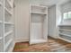Bright walk-in closet has wood floors, white shelving, a hanging rod, and a window at 2175 James Aly, Atlanta, GA 30345