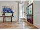Bright foyer featuring hardwood floors, console table with blue art, and dark wood front door with sidelight at 2175 James Aly, Atlanta, GA 30345