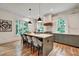 Bright kitchen features a large island with seating, modern pendant lighting, stainless steel appliances, and gray cabinetry at 2175 James Aly, Atlanta, GA 30345