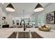 Open kitchen featuring large island with stone countertop and sink with black faucet open to living and dining areas at 2175 James Aly, Atlanta, GA 30345