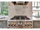 Close up of the high-end stainless steel range, marble tile backsplash, and views of the landscaped yard at 2175 James Aly, Atlanta, GA 30345