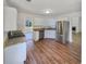 Well-lit kitchen with stainless steel appliances and laminate flooring, adjacent to living space at 2917 Yukon Nw Trl, Acworth, GA 30101