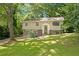 Split level home with lush green yard and a traditional front entrance surrounded by mature trees at 4690 Big Valley Ct, Stone Mountain, GA 30083