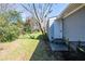 A cozy backyard featuring a lawn with a tree near a home's white door and gray brick wall, offering a serene outdoor space at 1393 Vesta Ave, Atlanta, GA 30344