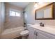 Bathroom featuring a shower-tub combination with tiled walls, a modern sink, and a large, framed mirror at 1393 Vesta Ave, Atlanta, GA 30344