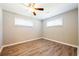 A cozy bedroom featuring wood-look flooring, a ceiling fan, and abundant natural light from two windows at 1393 Vesta Ave, Atlanta, GA 30344