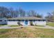 Charming single-story home with blue shutters, a blue door, and mature trees at 1393 Vesta Ave, Atlanta, GA 30344
