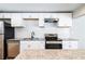 Modern kitchen featuring white cabinets, granite countertops, and stainless steel appliances at 1393 Vesta Ave, Atlanta, GA 30344
