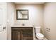 Bathroom features a dark vanity with a white countertop and stylish mirror and modern fixtures at 1780 Brewer Sw Blvd, Atlanta, GA 30310
