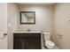 This bathroom features a dark wood vanity, a framed mirror, and a modern toilet at 1780 Brewer Sw Blvd, Atlanta, GA 30310