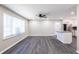 Spacious living room with gray floors, ceiling fan, and new kitchen with stainless appliances beyond breakfast bar at 264 Silver Springs Sw Cir, Atlanta, GA 30310