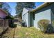 Side yard featuring green grass, partial fencing, and home's green brick exterior at 264 Silver Springs Sw Cir, Atlanta, GA 30310
