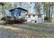 Backyard view of a house with a deck, bushes and green trees at 2887 Hickory Ln, Snellville, GA 30078