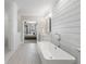 Modern bathroom featuring a soaking tub, walk-in shower, and access to the Primary bedroom at 557 Stone Field Nw Run, Marietta, GA 30060