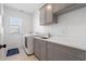Well-lit laundry room with modern washer, dryer, sink, and ample storage space at 557 Stone Field Nw Run, Marietta, GA 30060