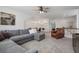Spacious living room with a comfortable gray sectional sofa, ceiling fan, and convenient kitchenette at 557 Stone Field Nw Run, Marietta, GA 30060