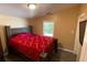 Bedroom featuring a bed with a red cover, wood floors, and a window with natural light at 615 Woodruff Rd, Carrollton, GA 30116