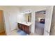 Bright bathroom with double sinks and doorway leading to the Primary bedroom at 2409 Brynfield Cv, Suwanee, GA 30024