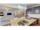 Kitchen featuring a granite-top island with sink and stainless steel appliances, open to the living area at 2409 Brynfield Cv, Suwanee, GA 30024