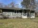 Exterior shot of home with green siding, a white lattice porch, and an overgrown front yard at 406 Dallas Hwy, Villa Rica, GA 30180