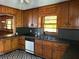 Kitchen with dark countertops, wood cabinets, black and white patterned flooring, and updated appliances at 406 Dallas Hwy, Villa Rica, GA 30180