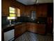 Kitchen with dark countertops, wood cabinets, black and white patterned flooring, and updated appliances at 406 Dallas Hwy, Villa Rica, GA 30180