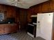 Kitchen featuring wood cabinetry, black countertops, an adjacent refrigerator and geometric flooring at 406 Dallas Hwy, Villa Rica, GA 30180
