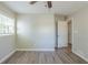 Comfortable bedroom featuring wood-look flooring, neutral walls, ceiling fan, and a sunny window at 1477 Patricia Dr, Morrow, GA 30260