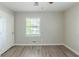 Cozy bedroom featuring wood-look flooring, neutral walls, ceiling fan, and a window with tree view at 1477 Patricia Dr, Morrow, GA 30260