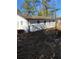 Side view of charming one story house with white brick and siding, and lush backyard at 1905 Robinhill Ct, Tucker, GA 30084