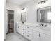 Bathroom with dual sinks, white cabinets, and a view into a walk-in closet at 4285 Haynes Cir, Snellville, GA 30039