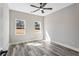 Bright bedroom featuring wood-look floors, a ceiling fan, and natural light from the windows at 4285 Haynes Cir, Snellville, GA 30039