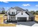 Newly constructed two-story home with a stylish facade, black framed windows and a two car garage at 4285 Haynes Cir, Snellville, GA 30039