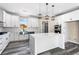 Bright white kitchen with stainless steel sink, white cabinets and granite counter tops with gray wood floors at 4285 Haynes Cir, Snellville, GA 30039