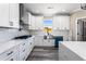 Gorgeous white kitchen with stainless steel sink, white cabinets and granite counter tops with gray wood floors at 4285 Haynes Cir, Snellville, GA 30039