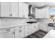 New kitchen features white cabinets, modern backsplash, stainless steel hood, gas cooktop, and stainless steel sink at 4285 Haynes Cir, Snellville, GA 30039