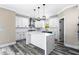 Modern white kitchen with marble island, stainless hood, white cabinets and gray wood floors at 4285 Haynes Cir, Snellville, GA 30039