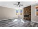Open living room with stone fireplace, ceiling fan, and wood-look floors at 4285 Haynes Cir, Snellville, GA 30039
