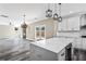 Open-concept living room boasts stone fireplace, lots of light, and access to kitchen with designer light fixtures at 4285 Haynes Cir, Snellville, GA 30039