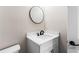Close up of a modern half bath with a round mirror, vanity with white countertop and black faucet at 4285 Haynes Cir, Snellville, GA 30039