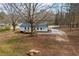 Aerial view of the home, deck, surrounding trees, and gravel driveway at 75 Woodfield Rd, Covington, GA 30014