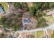 Aerial view of a home nestled among trees, with a long driveway and nearby neighborhood streets at 75 Woodfield Rd, Covington, GA 30014